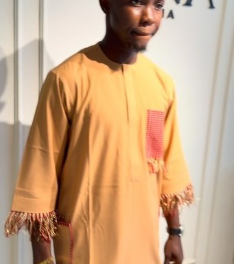 Close detail of a marigold kaftan with woven pocket and fringed hem