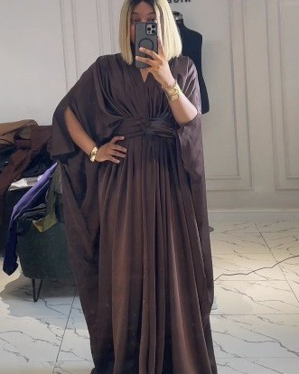 Woman in a chocolate brown draped bubu gathered at the waist