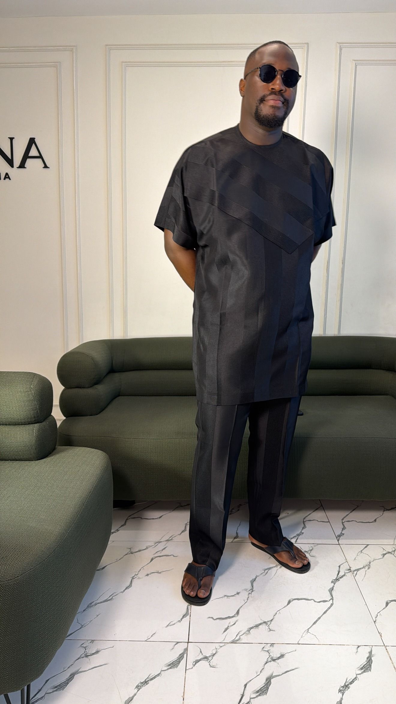 Man in a black tonal jacquard two-piece, hands behind his back